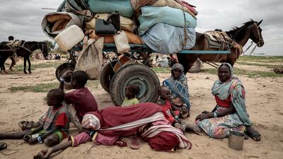 A Sudanese family who fled the conflict in the Darfur region wait with their belongings to be registered by the UNHCR, upon crossing the border between Sudan and Chad in Adre, Chad, on July 26, 2023. Reuters