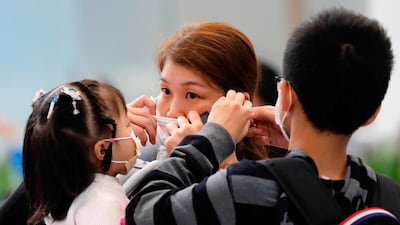 A woman adjusts her mask at the Hong Kong West Kowloon High Speed Train Station. Reuters