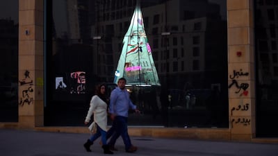An illuminated Christmas tree made from protest banners by Lebanese anti-government demonstrators is reflected in a shop window at Martyrs Square in Beirut. EPA