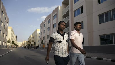 Workers’ Village residents Raja Shekar, left, and his roommate Rajanna Neelam, both from India, walk through the compound in Mussaffah. Silvia Razgova / The National