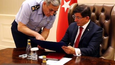 Commander of the Turkish air forces and full general Akin Ozturk, left, briefing Turkey's prime minister Ahmet Davutoglu, right, during a special security meeting on Daesh in Syria and the PKK in Iraq, at the Cankaya Palace in the capital Ankara on July 25, 2015. Hakan Goktepe/Handout picture from Turkish prime minister's office via AFP