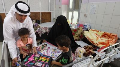 The UAE's Humanitarian Operations Director for Yemen, Saeed Al Kaabi, left, presenting gifts to Yemeni children diagnosed with malnutrition at a hospital in Mukalla. AFP.
