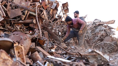Displaced Syrians working in a junkyard in the town of Batabo, between Idlib and Aleppo provinces in north-west Syria, in 2021. Reuters