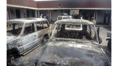Police officers and workers gather next to damaged vehicles, a day after a husband-and-wife team of Taliban suicide bombers attacked a police station in Kolachi, near Dera Ismail Khan, Pakistan, killing 10 people. Ishtiaq Mahsud / AP Photo