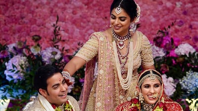 Isha, centre, daughter of Reliance Industries Chairman Mukesh Ambani, gestures as her brother Akash Ambani, left, and sister-in-law Shloka Mehta perform a ritual at their wedding ceremony in Mumbai, India on Saturday. Photo: Reliance Industries Limited Photo via AP