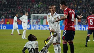Osasuna Unai Garcia gestures as Real Madrid's Luka Modric helps injured teammate Vinicius Junior. AFP