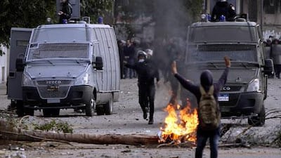 A protester opposing the Egyptian president Mohammed Morsi tries to stop police from firing tear gas along Qasr Al Nil bridge, which leads to Tahrir Square in Cairo, on Sunday. Mr Morsi declared a state of emergency last night for three Suez Canal provinces. Amr Abdallah Dalsh / Reuters