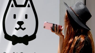 A woman using her smart phone walks outside a branch of SoftBank Corp in Tokyo, Japan. The mobile business may sell a 30 per cent stake. /Yuya Shino/Reuters