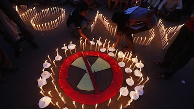 Greenpeace activists participate in a candle-lit vigil near the India Gate war memorial in New Delhi on April 11, 2001.