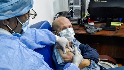 A medical worker administers a dose of Russia's Sputnik V vaccine on a man at a clinic in the city of Blida. AFP