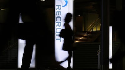 Pedestrians walk past a signboard of Recruit Holdings in front of its building in Tokyo on September 10, 2014. Japan's largest recruitment company Recruit Holdings said it is planning an initial public offering worth 193 billion yen ($1.8 billion), which will test investor appetite for big Tokyo listings after some weak debuts this year. Yuya Shino / Reuters