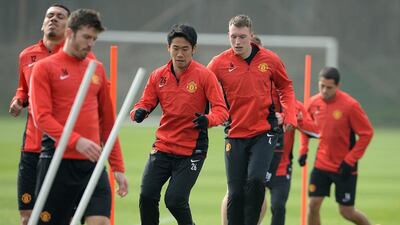 Manchester United players Shinji Kagawa, centre, and Phil Jones, to his right, attend a training session at the AON training complex in Manchester, England, on Monday. Manchester United face Bayern Munich in a Champions League quarter-final first leg on Tuesday. Peter Powell / EPA / March 31, 2014