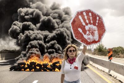 Israeli protesters hold banners and block the road during the demonstration demanding an agreement for the release of Israeli hostages in Gaza. Getty Images
