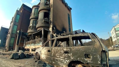 A burnt vehicle sits after being hit by a massive forest fire. Yonhap / AP