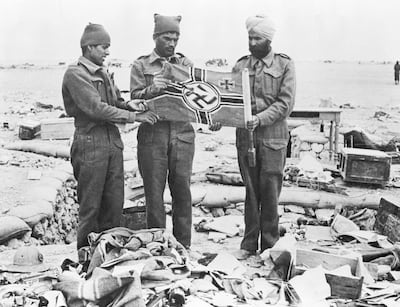 Indian troops with a Nazi flag in the rubble of Western Desert trenches of Libya in May 1942. Up to 2.5 million Indians fought for Britain during the Second World War. Getty