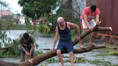 Men cut down a tree that fell due to strong winds as Typhoon Kammuri slammed Legazpi city, Albay province, southeast of Manila, Philippines. AP Photo