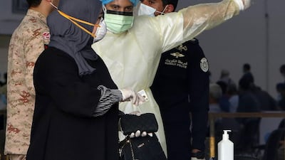 Kuwaiti health ministry workers prepare to scan expatriates living in Kuwait who returned from Egypt, Syria and Lebanon, as they arrive in Kuwait City. AFP