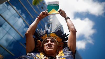 Nando Potiguara from the Potiguara tribe holds a copy of the Brazilian constitution during a protest against violence suffered by Yanomami Indigenous people in Brasilia, Brazil, on May 6, 2022. Reuters