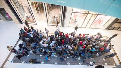 Apple customers queue through the night to be one of the first to get the new Apple devices. Leslie Pableo / The National