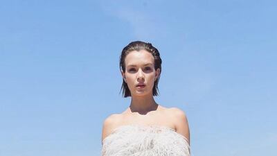 Josephine Skriver is elegance personified in a couture autumn–winter 2021 look, an all-white, strapless top with plisse trousers, topped with feathers. Photo: Rami Al Ali