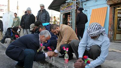 People light candles at the site of Monday's twin suicide bombings in Baghdad, Iraq. Karim Kadim/AP
