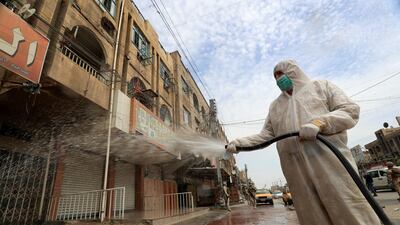 An Iraqi soldier wearing a protective suit sprays disinfectant to sanitise a street, during a curfew in Baghdad, Iraq. Reuters