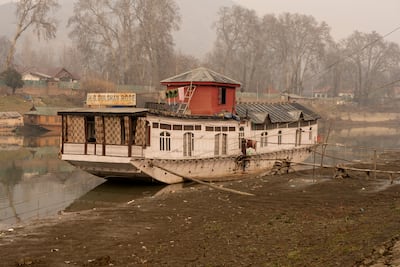 A houseboat remains moored on the Jhelum river in Srinagar because of the low water levels. Wasim Nabi for The National