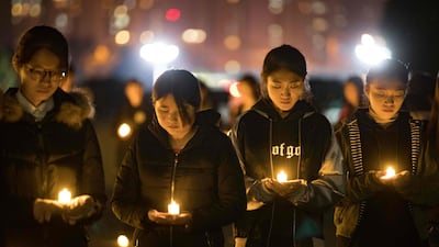 Students holding candles at Nanjing Normal University during a memorial ceremony ahead of China's National Memorial Day for Nanjing massacre victims in Nanjing city. AFP Photo