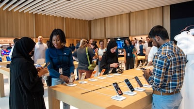 Shoppers try out the latest Apple devices at the Al Ain store