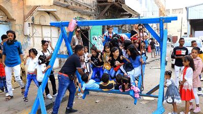 Yemeni children sit on a ride as people celebrate the Eid Al-Adha in Aden. AFP