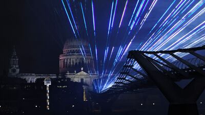 A laser display is seen above the Millennium Bridge with St Paul's Cathedral behind, an alternative to London's usual New Year's fireworks display. AFP