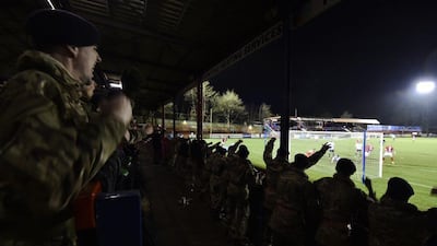 British Army personnel celebrate a goal as they watch the football match against the German Army on Wednesday to mark 100 years since the World War I Christmas Truce. The British Army won the match 1-0. Toby Melville / Reuters