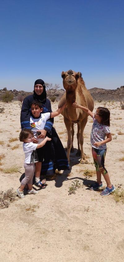 Ammal Farahat, her two children and her niece, during a weekend driving trip. It was the first time the children had seen a camel in the wild. Courtesy of Ammal Farahat.