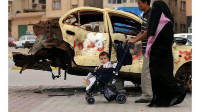 A Libyan family walks past a charred car in Benghazi. A reader who worked as a construction project manager in Benghazi and other Libyan cities expresses the hope that the current crisis will end favourably. Saeed Khan / AFP