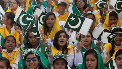 Attendees wave Pakistan's national flag while singing national songs at a ceremony to celebrate the country's 70th Independence Day at the mausoleum of Muhammad Ali Jinnah in Karachi, Pakistan August 14, 2017. REUTERS/Akhtar Soomro