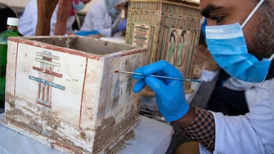 An archaeologist works on an artefact as sarcophaguses are presented to the media near the newly discovered burial site at Saqqara Necropolis in Giza. EPA