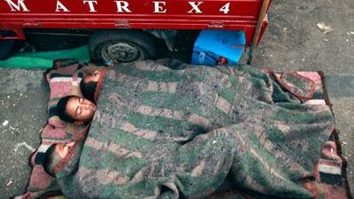 Men sleep next to van during sit-in at Tahrir Square, after court sentenced deposed president Mubarak to life in prison in Cairo.