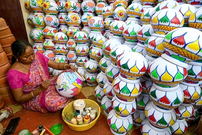 A woman paints earthenware pots ahead of the Hindu harvest festival Pongal in Chennai. AFP