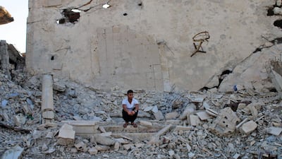 Moawiya Sayasina sits among the rubble in a rebel-held neighbourhood in the southern Syrian city of Daraa. Mohamad Abazeed / AFP