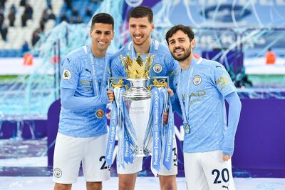Manchester City's Portuguese trio Joao Cancelo, Ruben Dias and Bernardo Silva celebrate with the Premier League trophy. Getty Images
