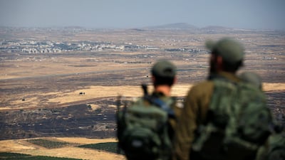 Israeli soldiers look at the Syrian side of the Israel-Syria border. Ronen Zvulun / Reuters
