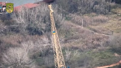 A screengrab from a video posted on Facebook showing a Ukraine flag flying from a crane the Dnipro river. @Спецпідрозділ "Карлсон" / Facebook