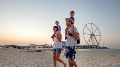Visitors at Dubai's Jumeirah Beach Residence enjoy the beach with Ain Dubai in the background in 2018.