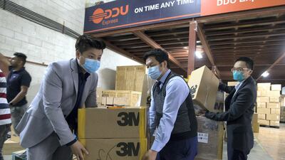 Volunteers help with boxes of face masks to be shipped to China. Leslie Pableo / The National