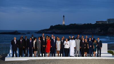 World leaders and guests pose for a family picture with the Biarritz lighthouse in the background on the second day of the annual G7 summit in France. AFP