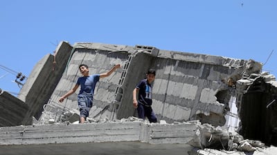 A Palestinian boy dances on the rubble of a building. Reuters