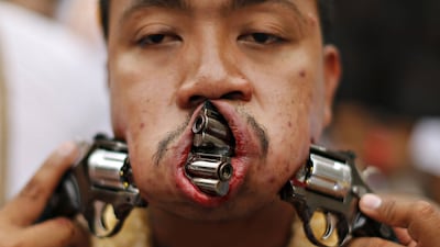 A devotee of the Chinese Bang Neow shrine walks with guns pierced through his cheeks during a procession celebrating the annual vegetarian festival in Phuket, Thailand. The festival, featuring face-piercing, spirit mediums and strict vegetarianism celebrates the local Chinese community’s belief that abstinence from meat and various stimulants during the ninth lunar month of the Chinese calendar will help them obtain good health and peace of mind. Jorge Silva / Reuters