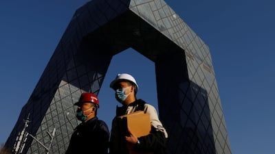 Workers walk past the CCTV headquarters, the home of Chinese state media outlet CCTV and its English-language sister channel CGTN, in Beijing after the British regulator removed its licence to broadcast in the UK. Reuters