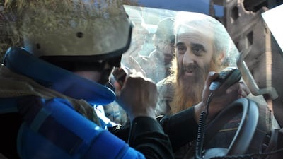 A man looks at a United Nations staff member ahead of being evacuated from the besieged district of the central Syrian city of Homs to a safer location on February 9, 2014. Bassel Tawil/AFP Photo