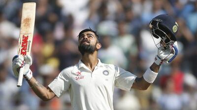 Indian captain Virat Kohli raises his bat and helmet after scoring double century on the fourth day of the fourth cricket Test match between India and England in Mumbai, India, on December 11, 2016. Rafiq Maqbool / AP
